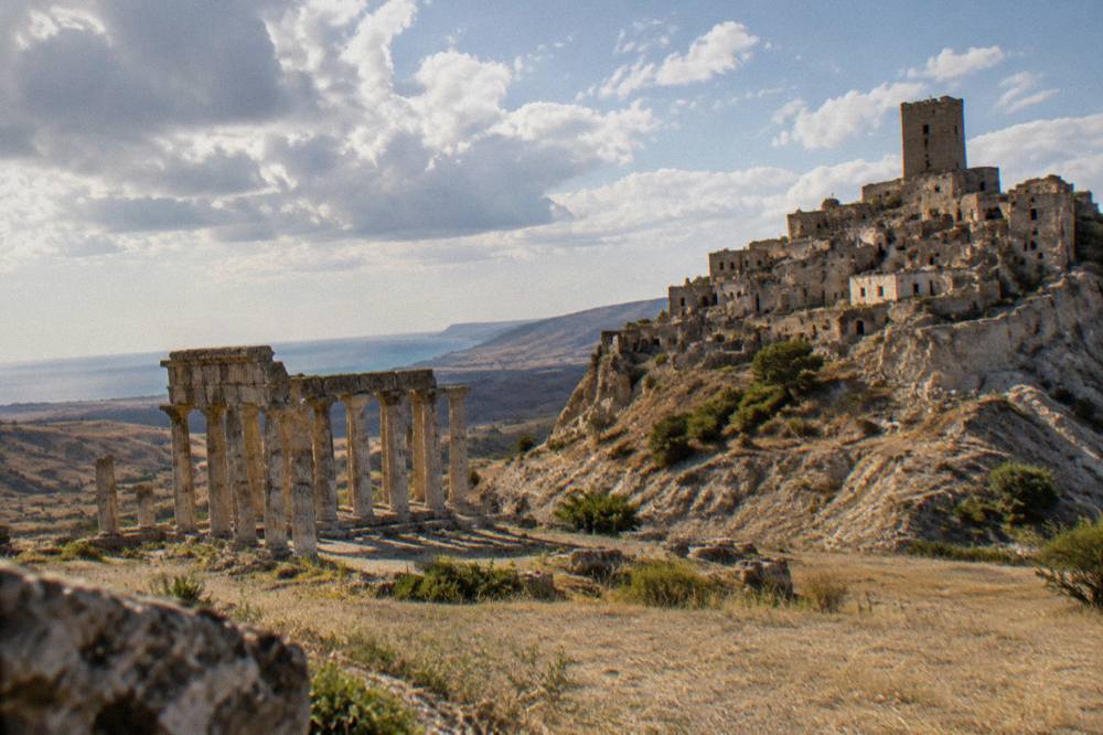 Ancient stone ruins of a Greek temple standing in a flat field near the Ionian coast of Basilicata