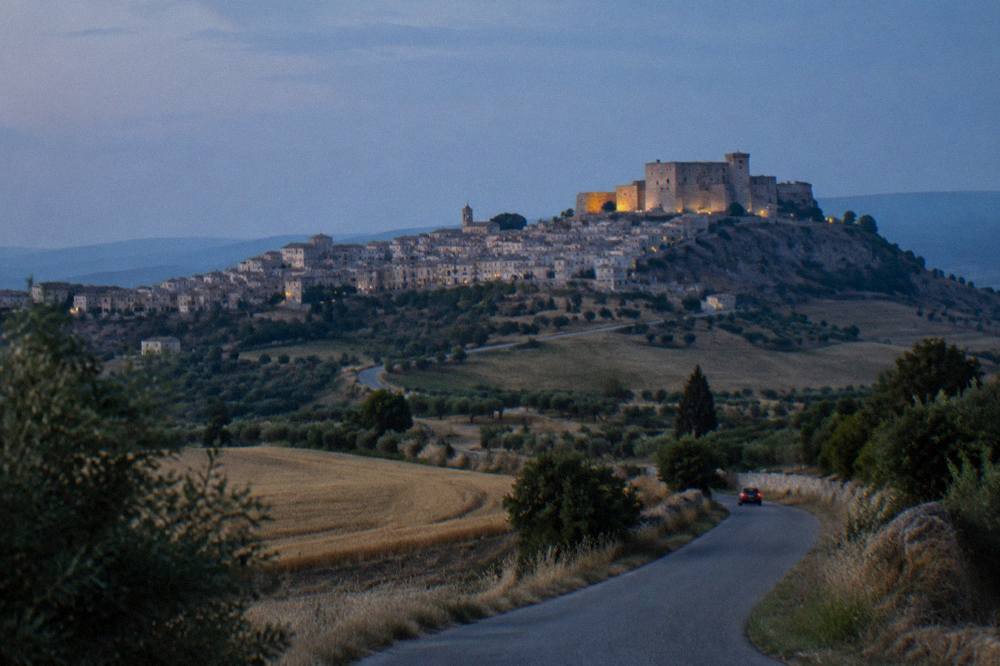 A country road winding through rolling farmland in southern Italy