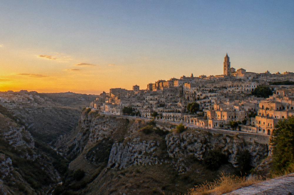 The Matera skyline seen from a distance across the ravine at golden hour