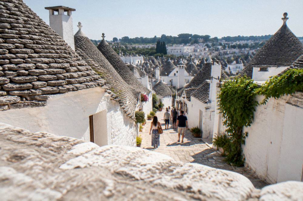 Whitewashed trulli houses with conical stone roofs in Alberobello seen from above