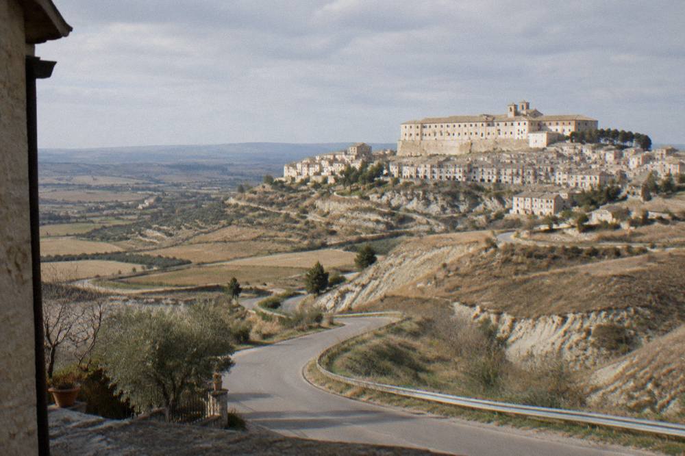 A winding country road crossing bare clay hills under a wide sky