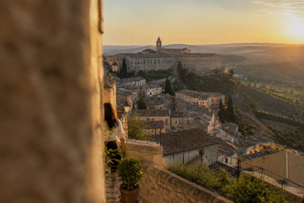 Golden afternoon light on stone rooftops and rolling green hills