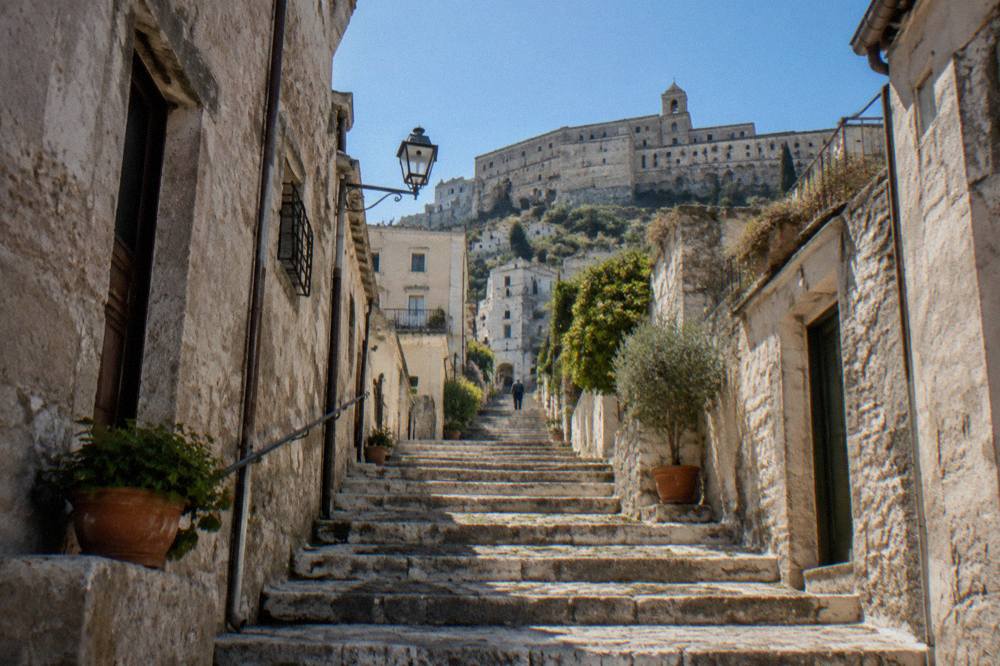 Stone steps rising between old houses in a quiet Italian hilltown lane