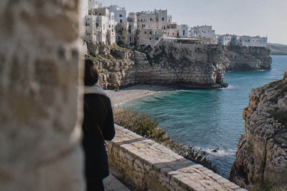 Turquoise water against pale limestone cliffs seen from a coastal path