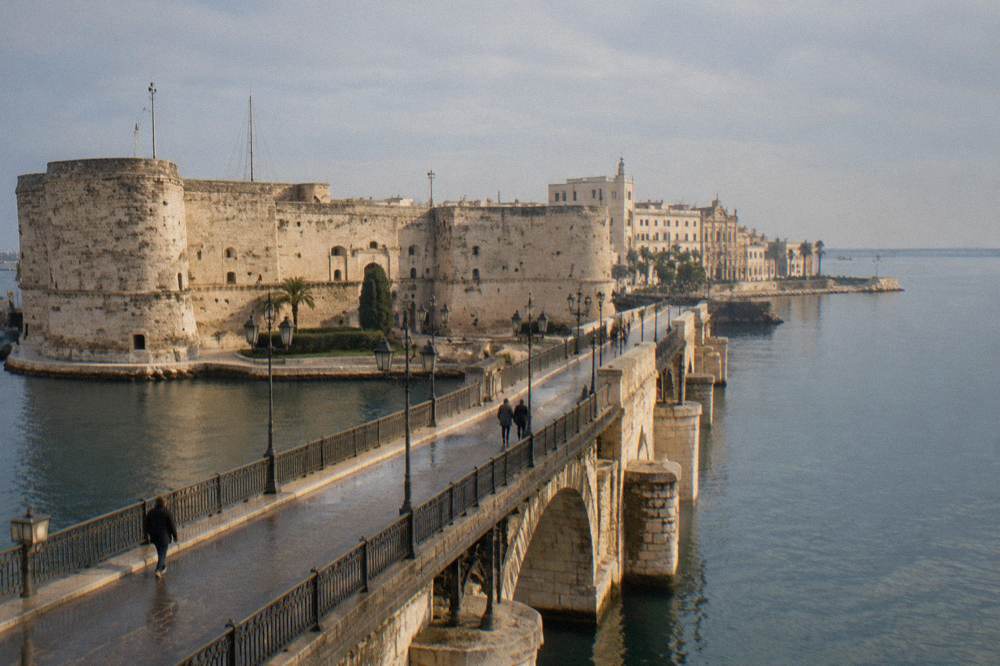 Stone bridge and castle walls at the entrance to the old town island of Taranto