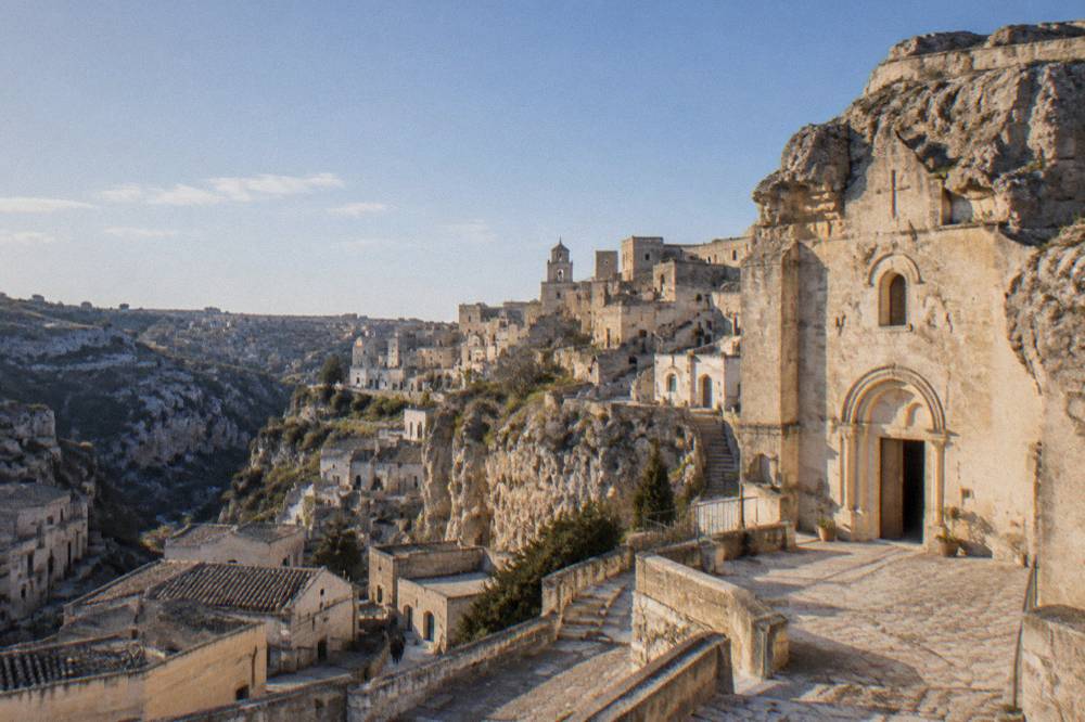 A rock-hewn church facade in the Sassi lit by late afternoon sun