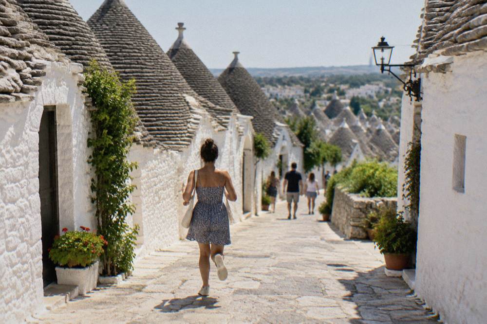 White trulli houses with conical stone roofs lining a street in Alberobello