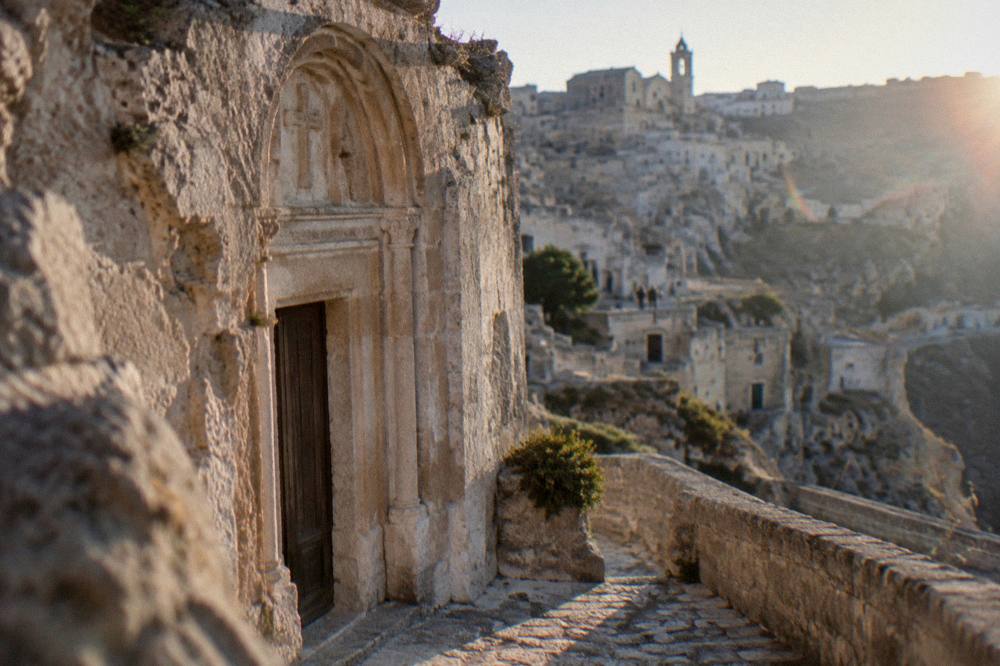 A rock-cut church facade with a carved portal in the Sassi of Matera