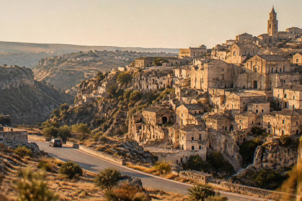 An open road crossing the plateau landscape of Basilicata towards the coast