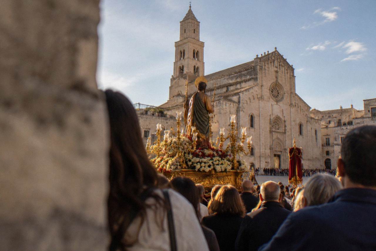 A decorated festival float in a crowded Italian square at dusk