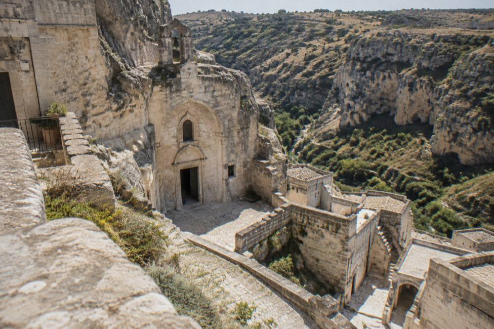 A rock-hewn church facade carved directly into the limestone cliff face