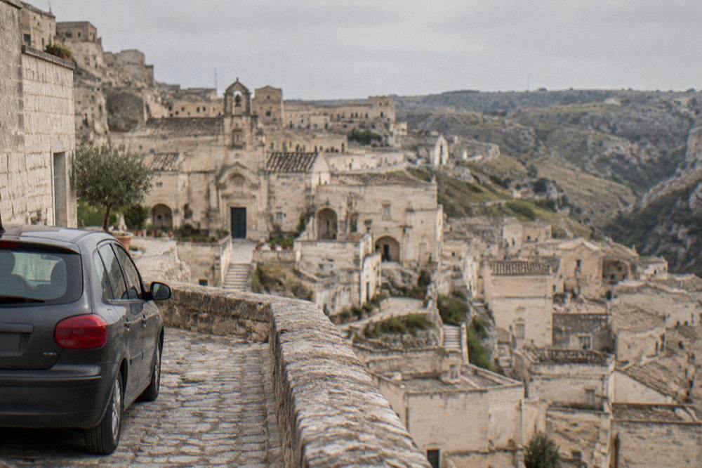 A hired car parked on a stone street above the Sassi rooftops