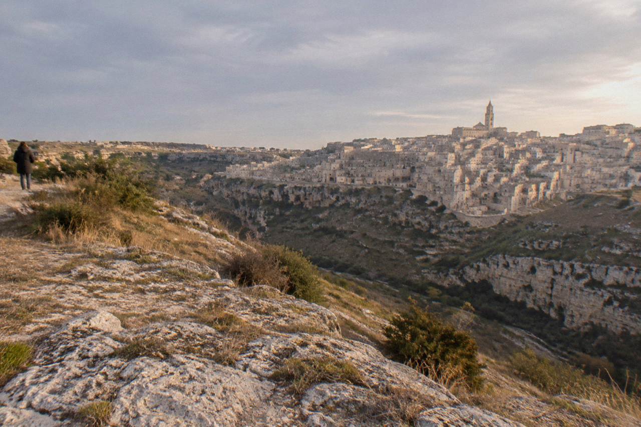 Cave houses and stone facades of the Sassi districts rising above the Gravina canyon at golden hour
