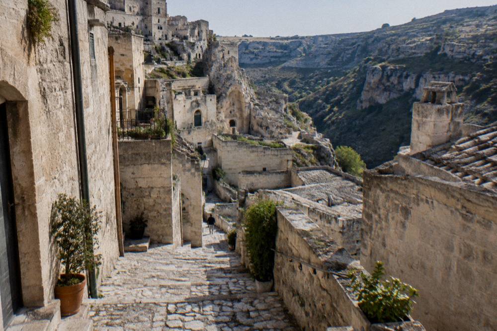 A narrow cobbled stairway descending between stone houses in Sasso Caveoso