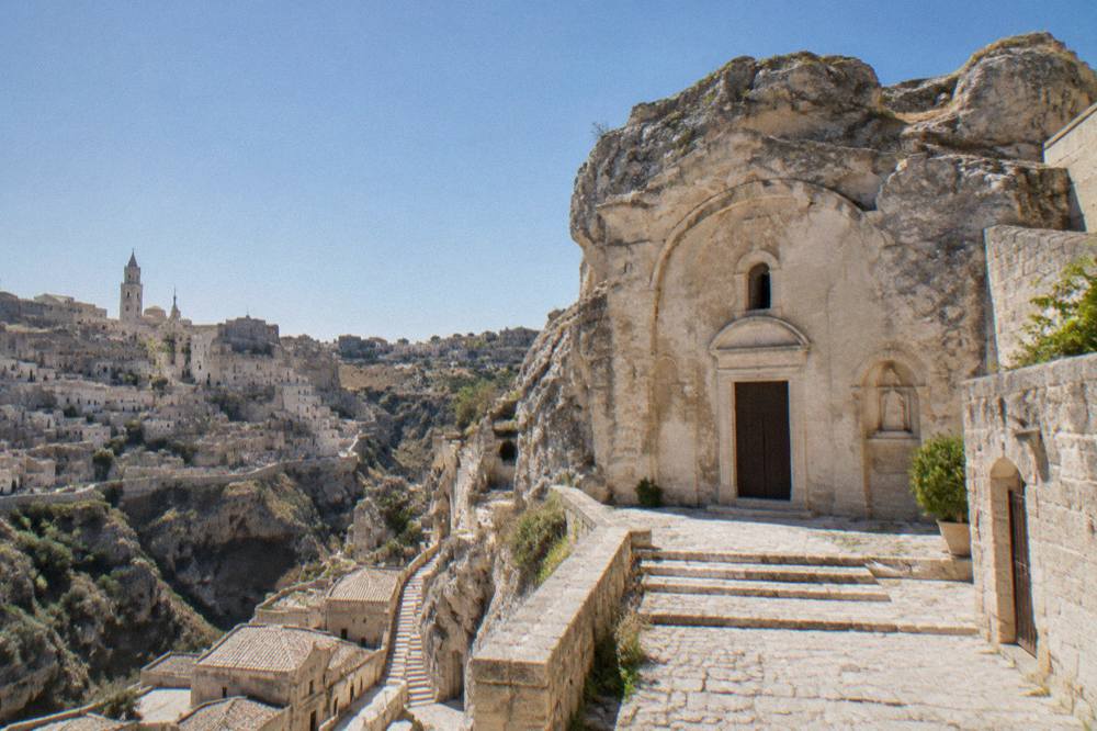 A rock-hewn church facade carved into pale stone in the Sassi of Matera