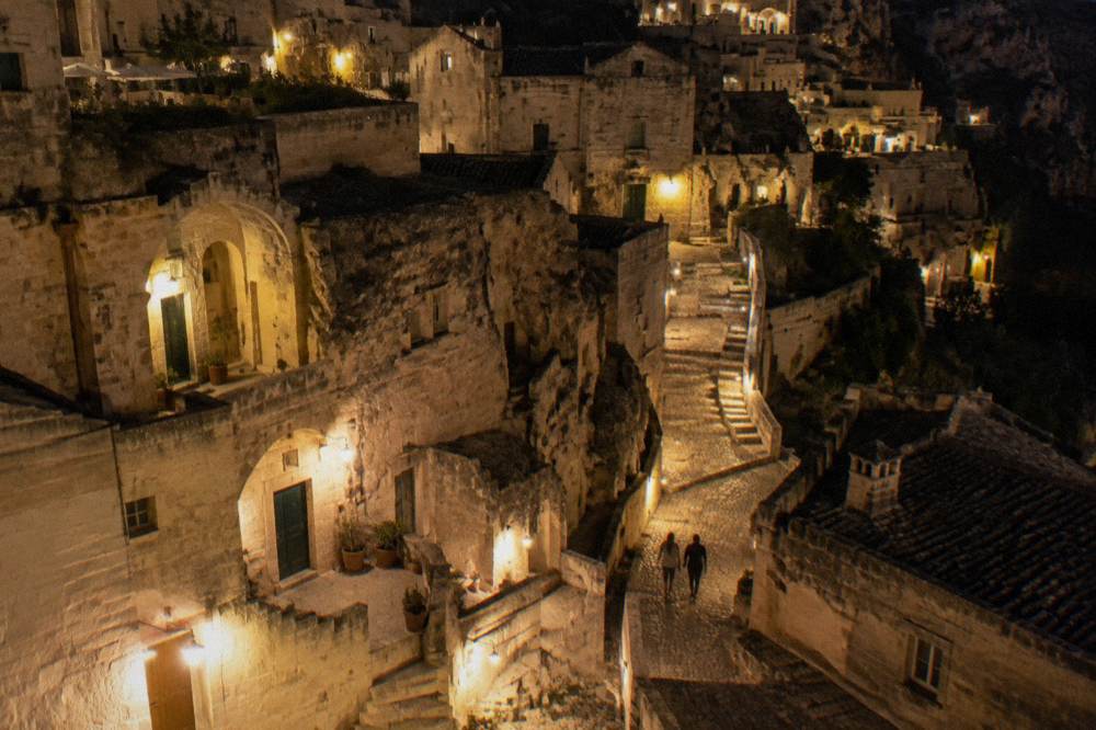Illuminated stone lanes and cave facades of Sasso Barisano in Matera at night