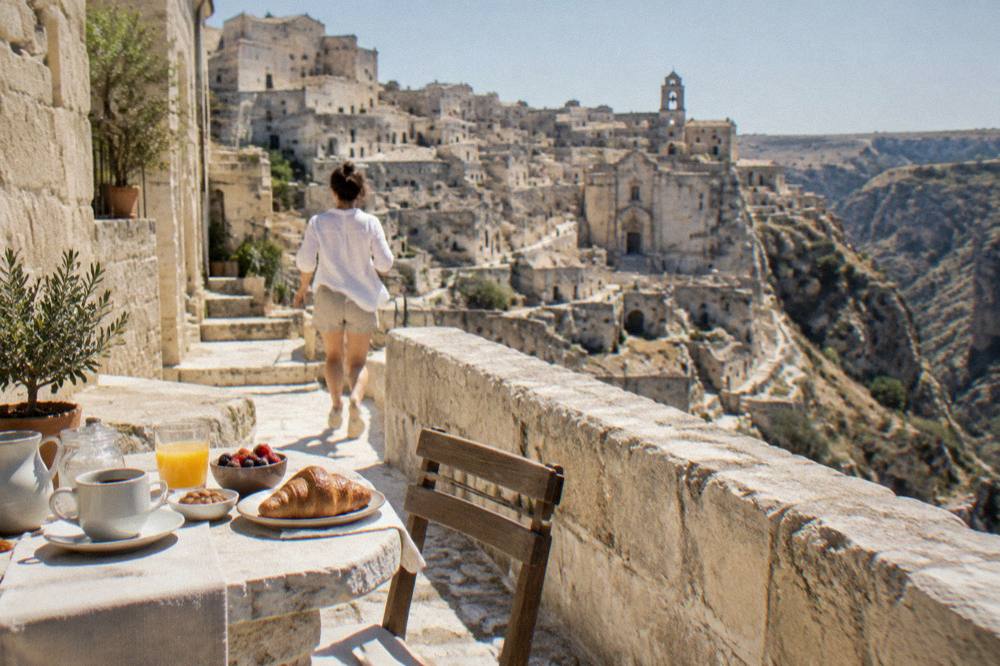 Breakfast laid out on a stone terrace overlooking the canyon and cave district of Matera