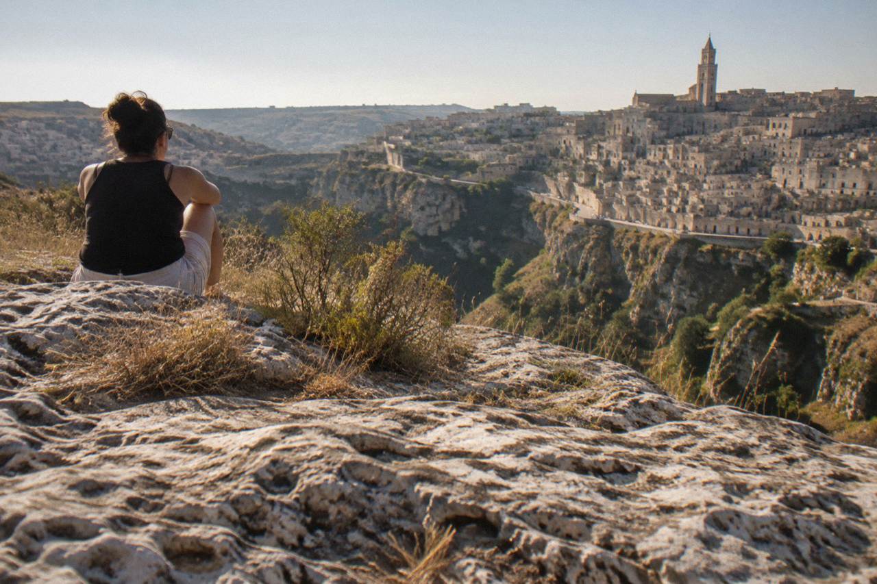 The cave dwellings of the Sassi district of Matera rising above the Gravina canyon at dusk
