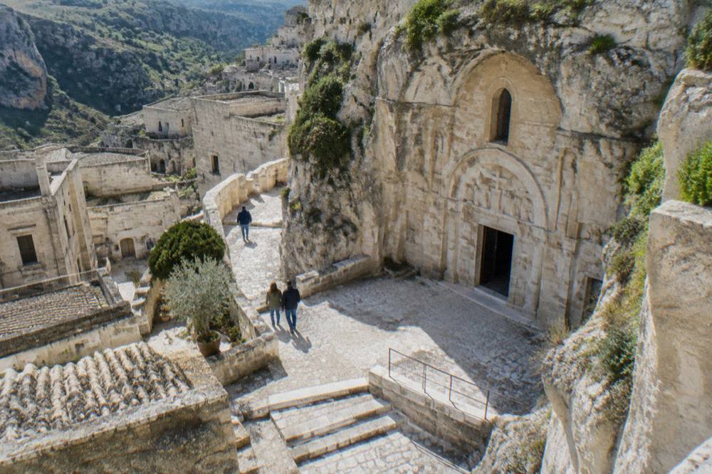 A rock-hewn church facade carved into pale limestone in the Sassi of Matera