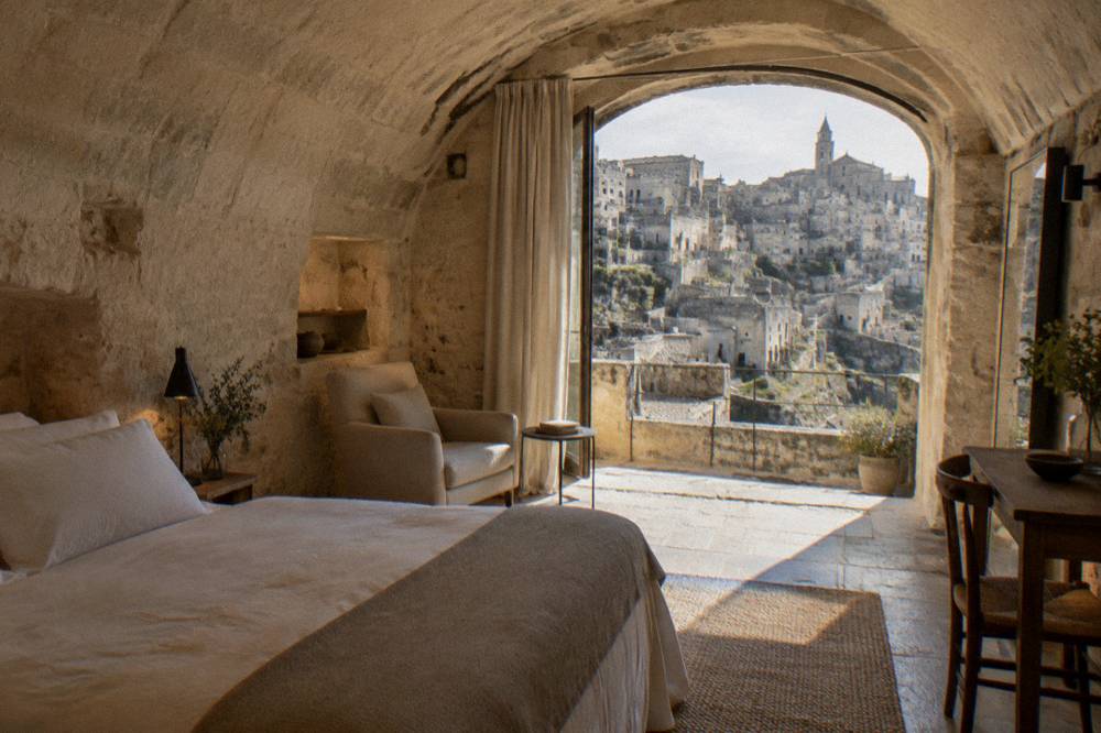 A restored cave hotel room with vaulted stone ceiling in the Sassi of Matera