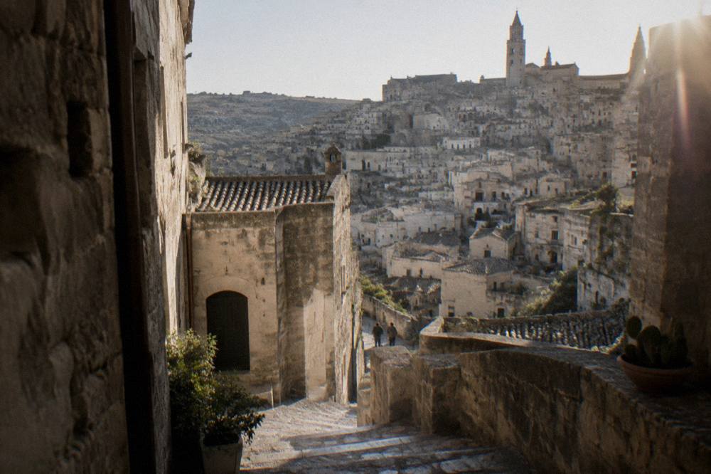 An Aperol spritz and a bowl of olives on a stone terrace above the Sassi of Matera