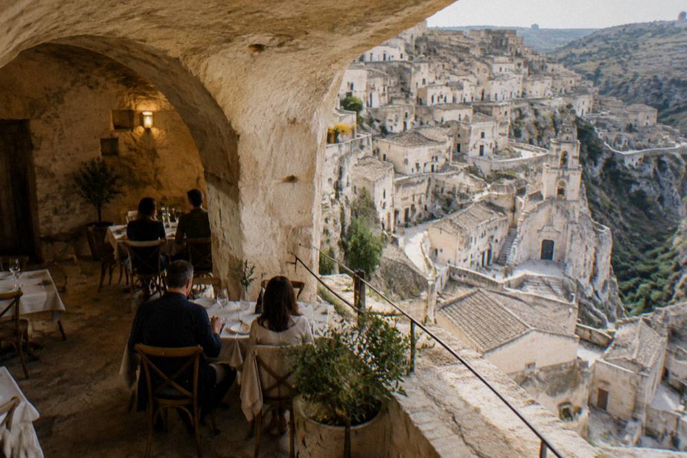 Diners at a table inside a vaulted cave restaurant in the Sassi of Matera