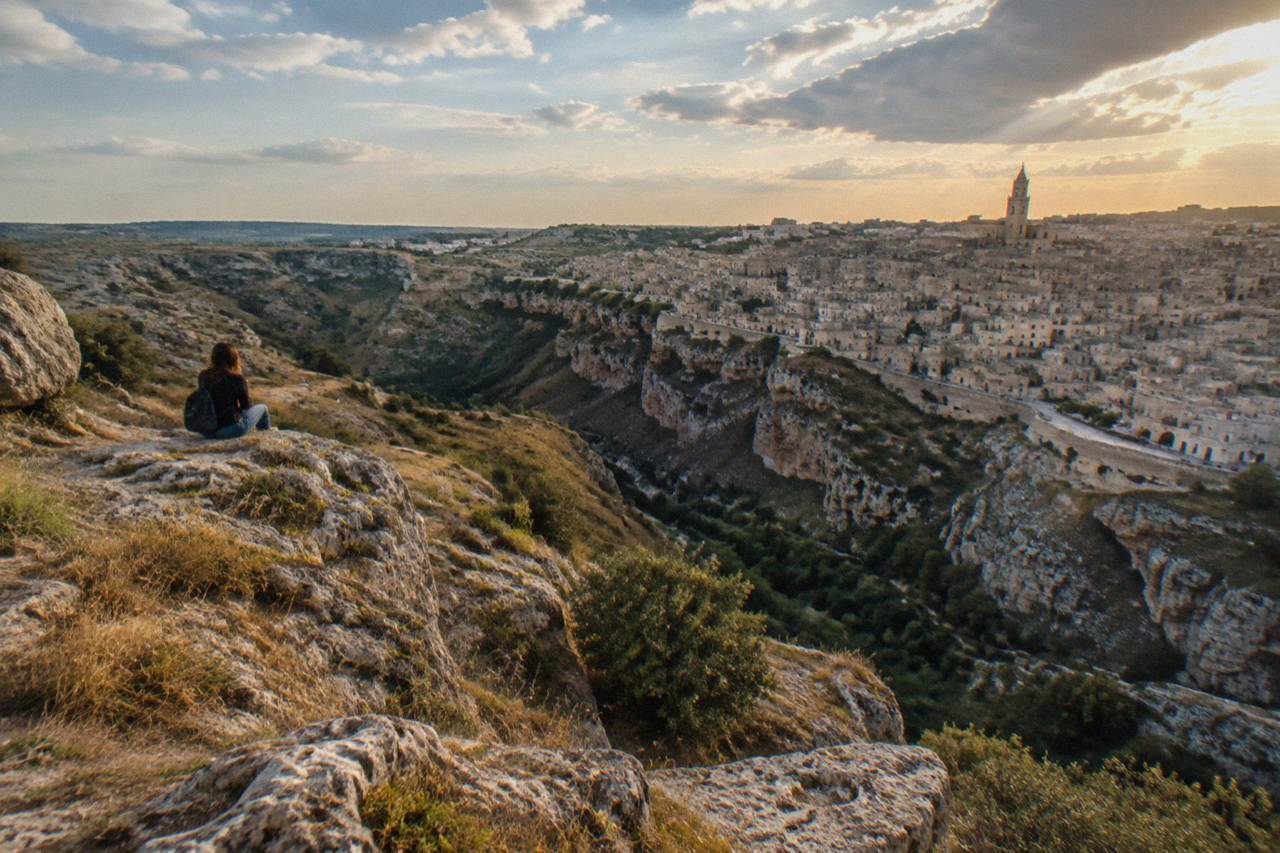 Cave dwellings and stone buildings of the Sassi of Matera seen across the Gravina canyon at dusk