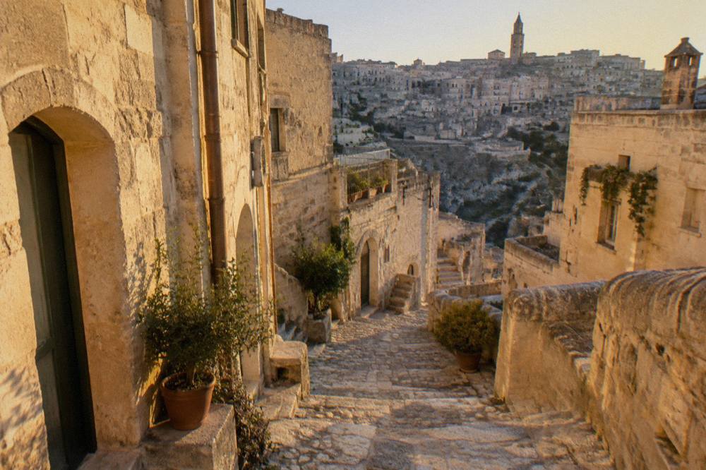 A narrow stepped lane between pale stone buildings in the Sasso Barisano quarter of Matera
