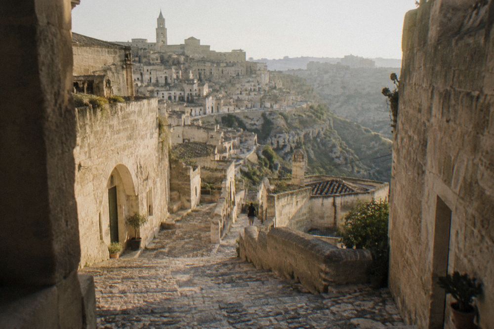Stone stairway descending between pale cave buildings in the Sasso Barisano quarter at dusk