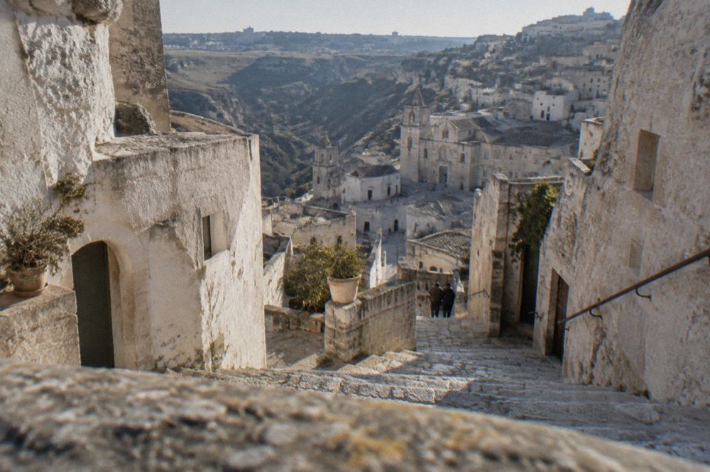 A stone staircase descending between whitewashed cave facades in the Sassi districts