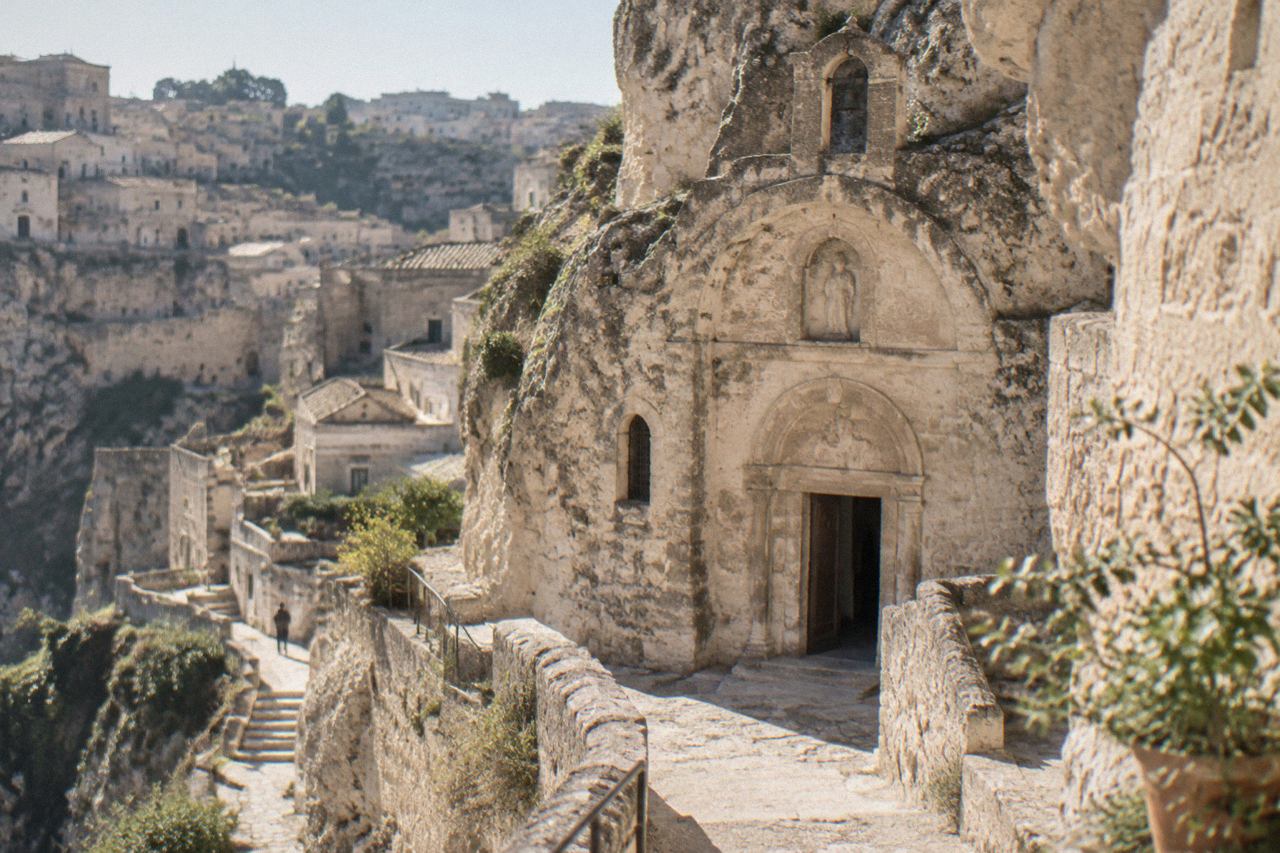 Rock-hewn church facade carved into pale limestone in the Sassi of Matera