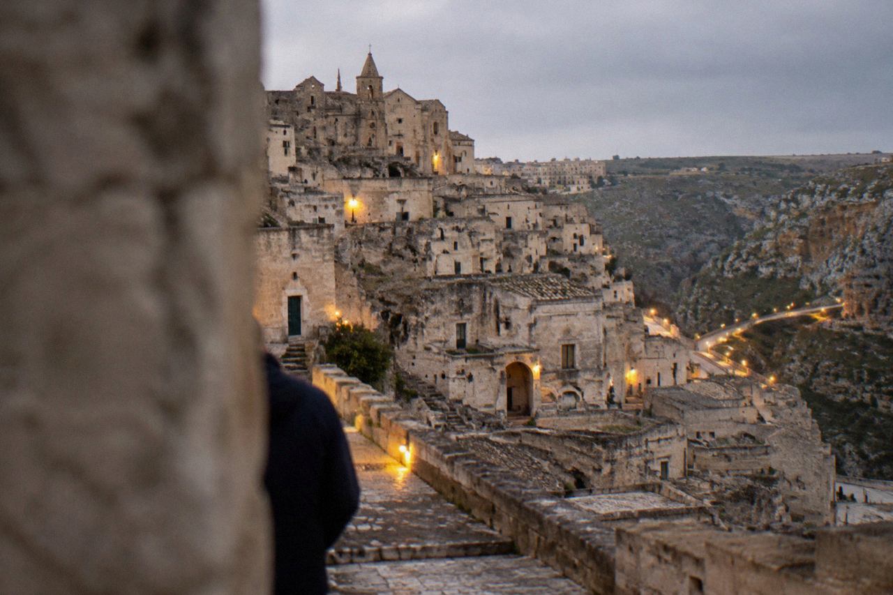 Evening view over the cave dwellings of the Sassi in Matera with warm lights along the canyon edge