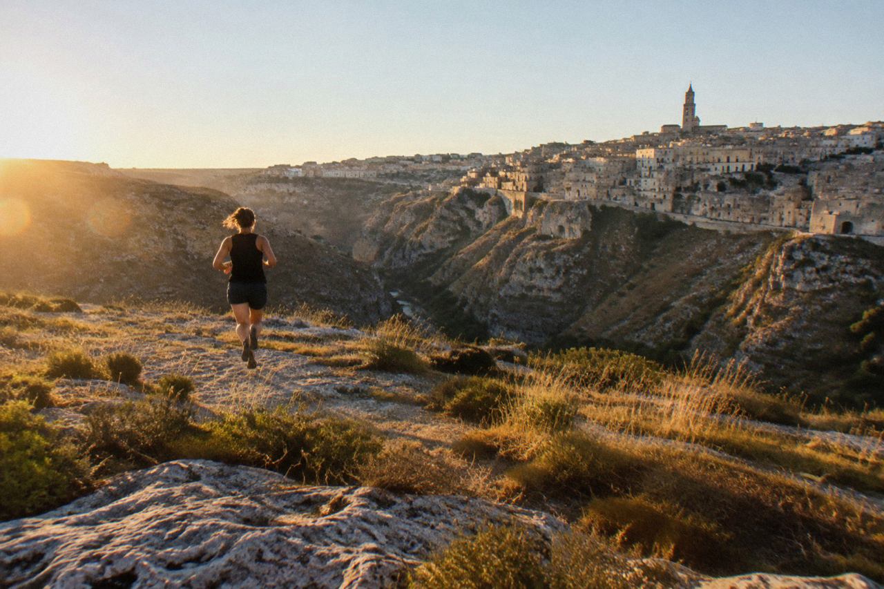 Pale stone buildings of the Sassi districts glowing under a clear summer sky above the Gravina canyon