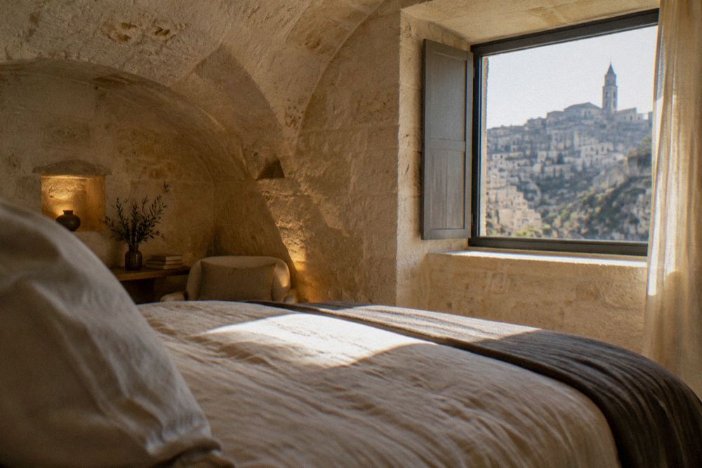 A cave hotel bedroom with arched stone ceiling and soft evening light through a small window