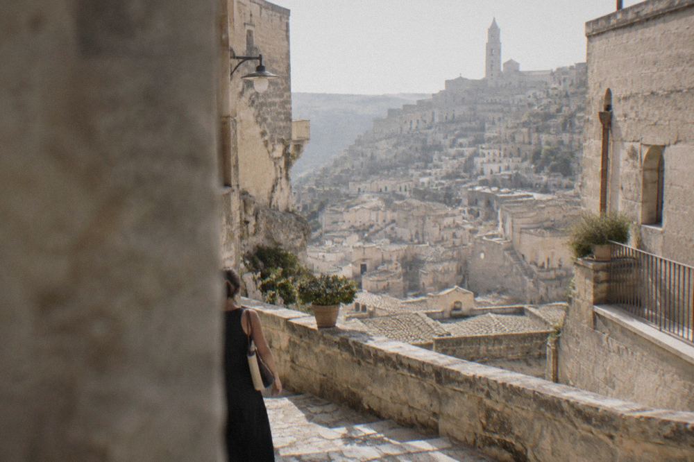 Costumed figures in a living nativity scene lit by lanterns along a stone lane in Matera