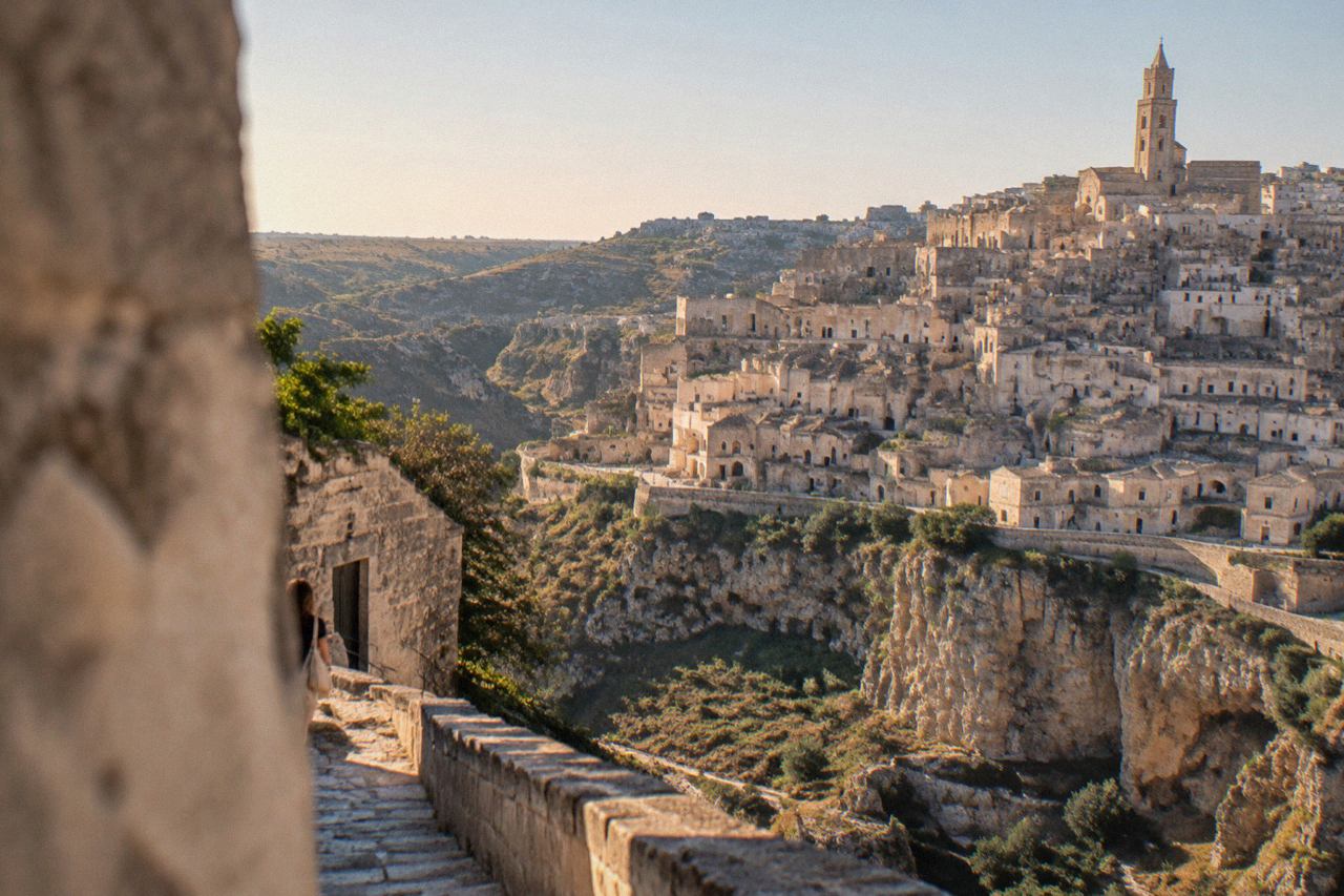 Panorama of the Sassi cave dwellings of Matera seen from across the Gravina canyon at golden hour