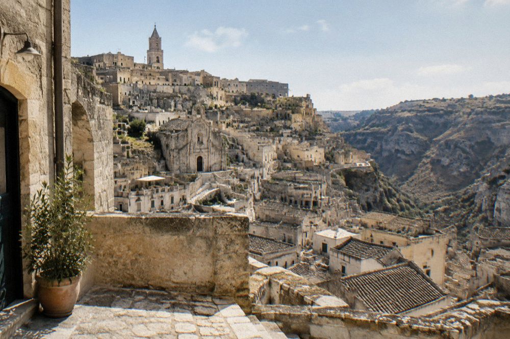 Photographer with a wide lens on a stone terrace above the Sassi rooftops