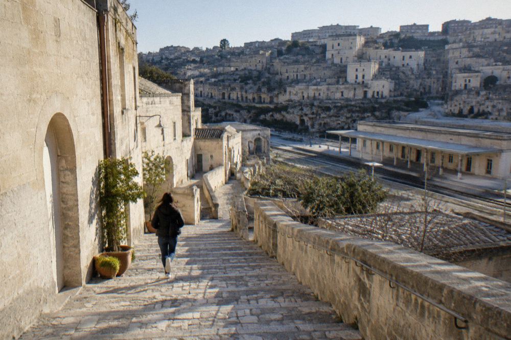 A steep stone staircase lined with pale limestone houses descending between cave dwellings