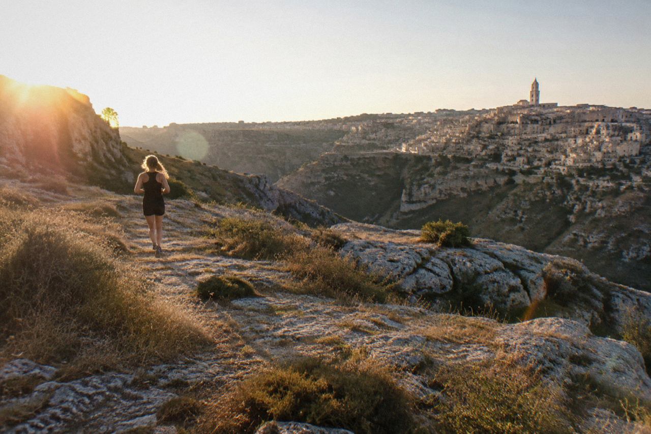 Pale stone houses and cave dwellings stacked above the Gravina canyon at Matera