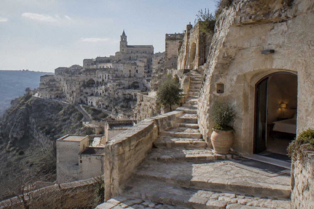 A restored cave hotel doorway with stone stairs climbing through the Sassi
