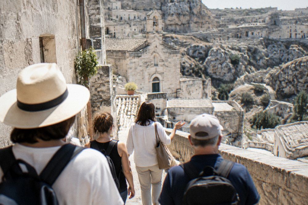 A licensed guide leading a small group through a lane in the Sassi of Matera