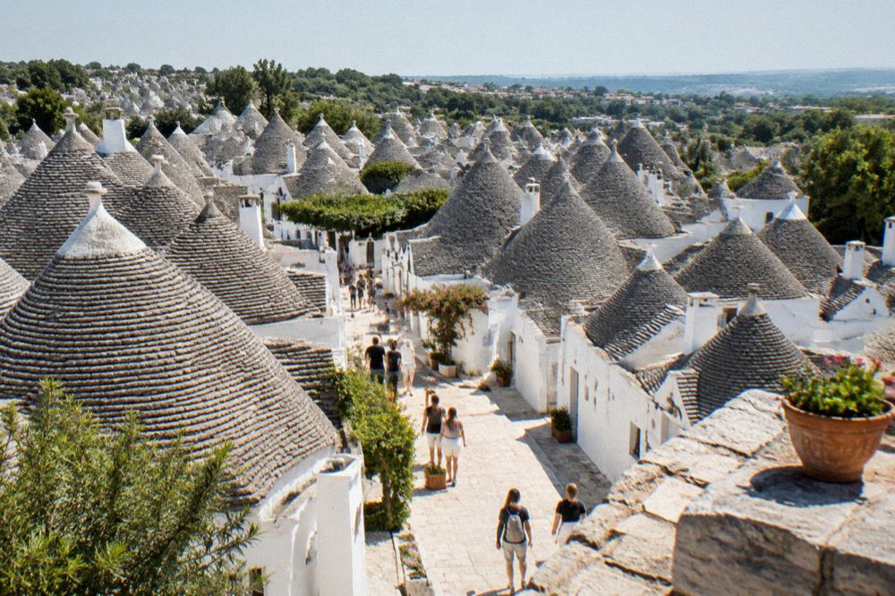 The whitewashed trulli cones of Alberobello seen from a viewpoint terrace