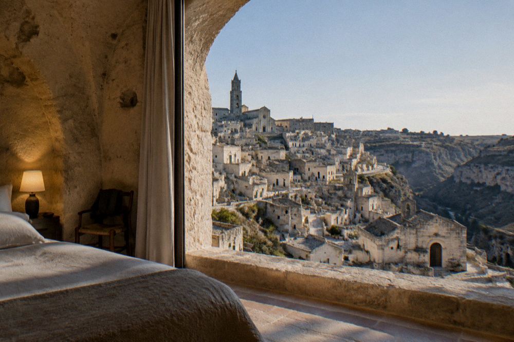 Warm lamplight in a vaulted cave hotel room carved from tufa stone