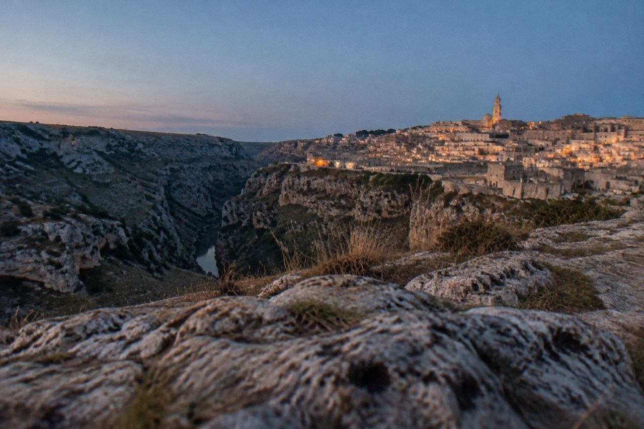 The cave houses of the Sassi district of Matera seen across the Gravina canyon at golden hour