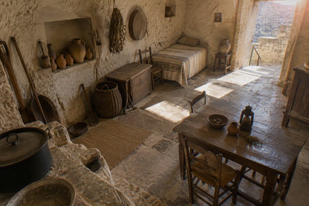 A furnished interior of a cave house museum in Matera with stone walls and period tools
