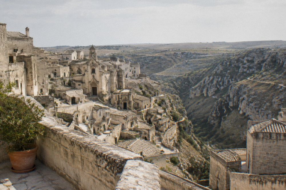 A stone balcony in Matera overlooking the canyon with the Murgia plateau on the horizon