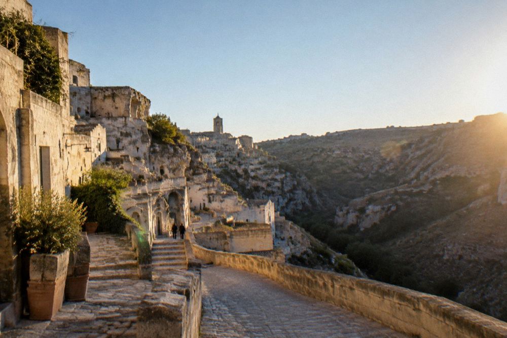 Stone stairways descending between tufa buildings toward the Sassi of Matera