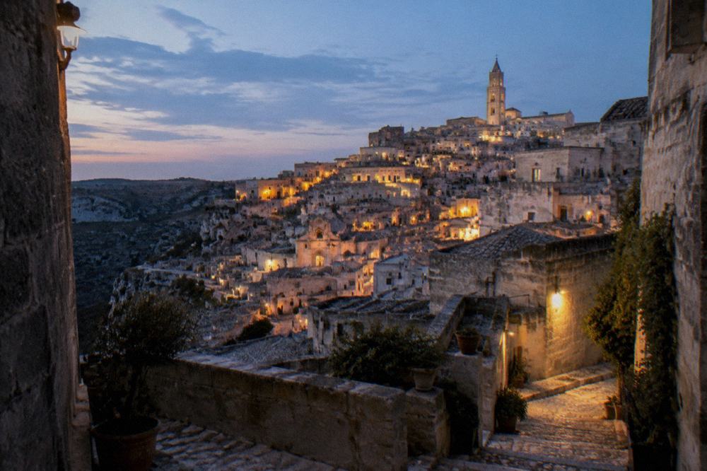 The Sassi districts of Matera illuminated at dusk with warm lights on stone facades