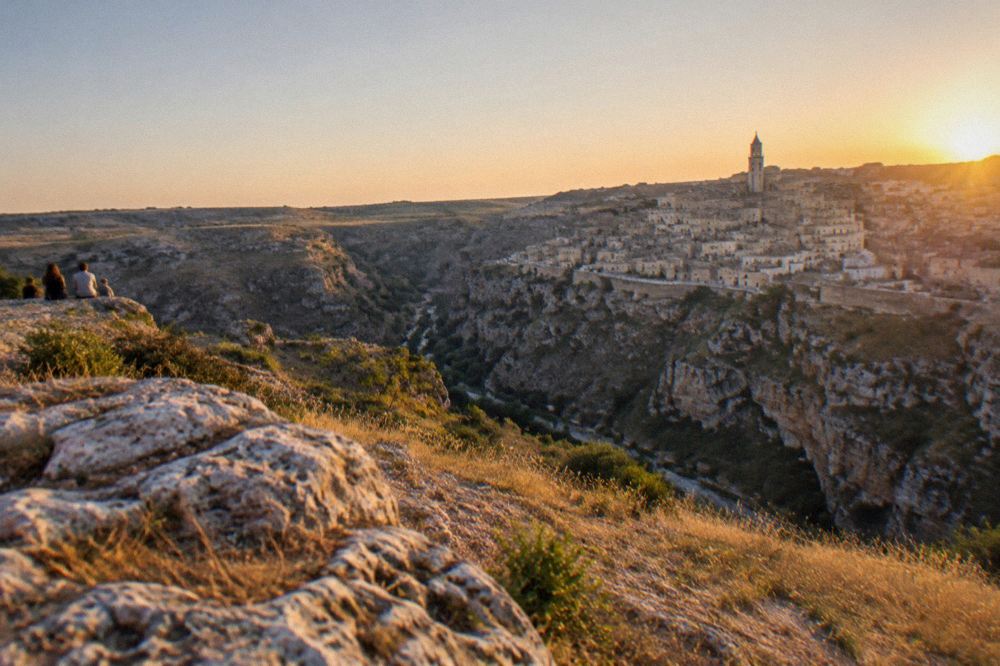Evening view over the cave dwellings of the Matera Sassi glowing above the Gravina canyon