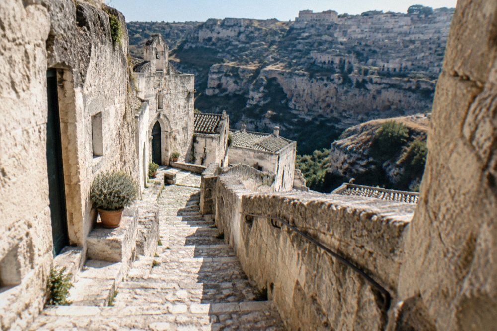 A steep stone stairway climbing between cave dwellings in Sasso Caveoso
